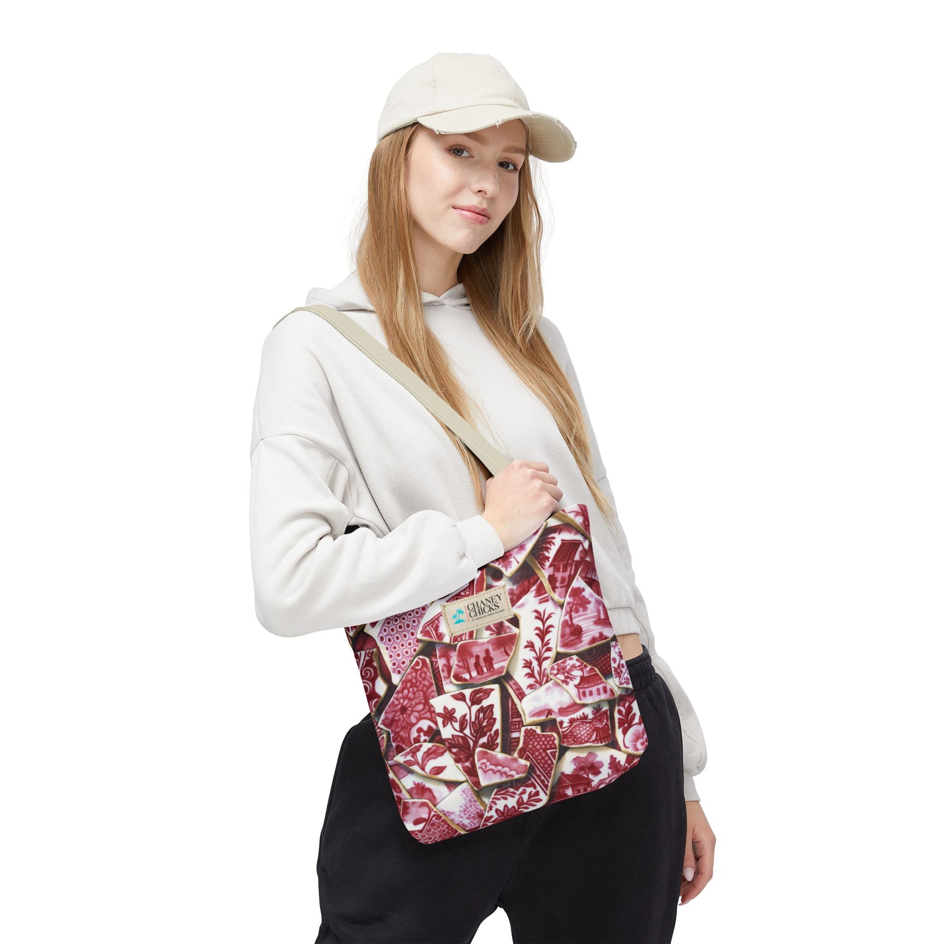 Person wearing a white cap and holding a patterned bag on a white background