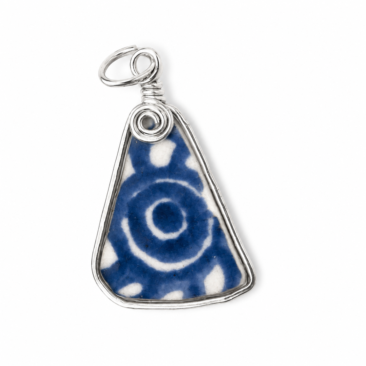 A triangular ceramic pendant with a blue and white spiral pattern, wrapped in a silver-toned metal frame with a wire bail, shown on a plain white background.